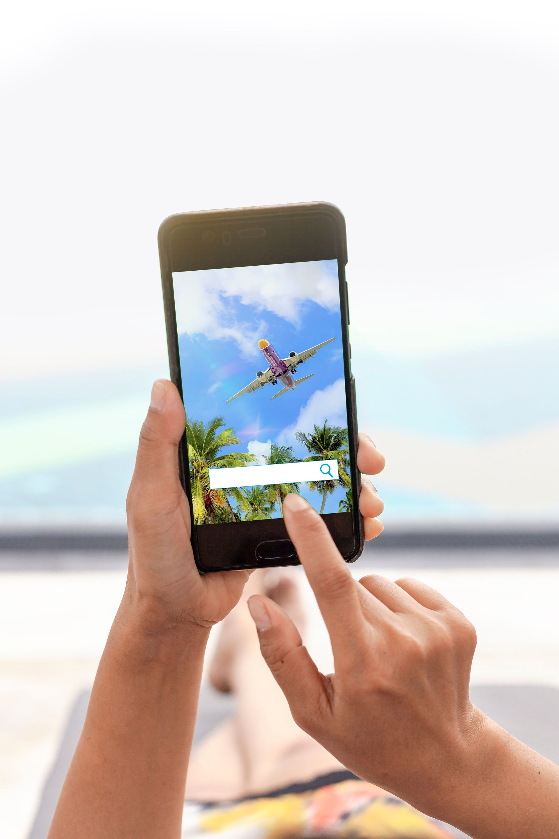 Picture of a woman relaxing by the pool. Her hands are touching the phone screen to explore new travel.